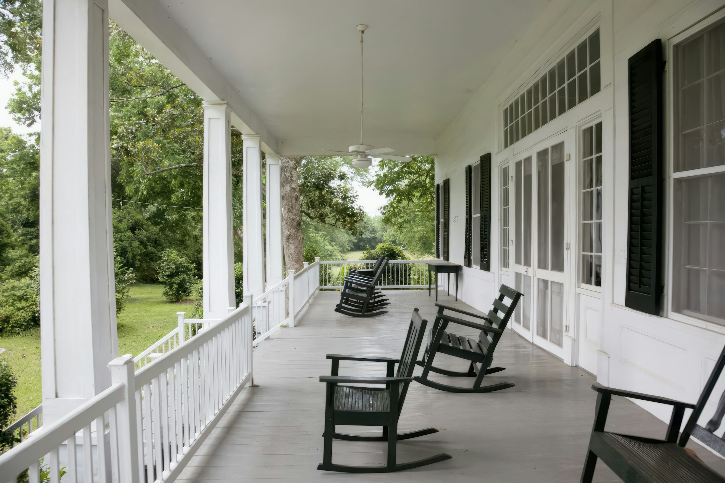 Sunlit Southern porch with white columns and rocking chairs